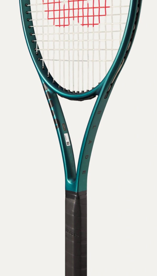 Close-up of a tennis racket with a white strings background